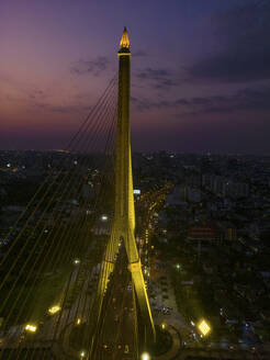 Aerial view of The Rama VIII Bridge, a cable-stayed bridge crossing the Chao Phraya River at night in Bangkok, Thailand. - AAEF20868