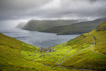 Storm clouds over the coastal village of Funningur along the fjord, Eysturoy Island, Faroe Islands, Denmark, Europe - RHPLF26412