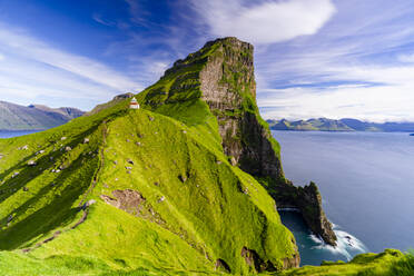 Kallur lighthouse on cliffs covered with grass with Borgarin mountain peak on background, Kalsoy island, Faroe Islands, Denmark, Europe - RHPLF26415