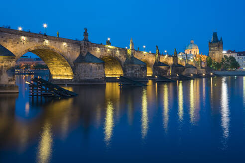 Illuminated Charles Bridge with reflections at twilight, UNESCO World Heritage Site, Prague, Bohemia, Czech Republic (Czechia), Europe - RHPLF26477