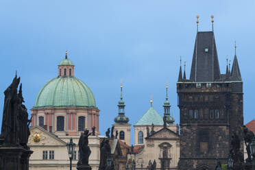 Details of statues and spires at Charles Bridge, featuring dome of Church of Saint Francis of Assisi and Old Town Bridge Tower, UNESCO World Heritage Site, Prague, Bohemia, Czech Republic (Czechia), Europe - RHPLF26482