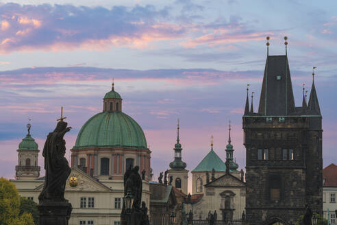 Details of statues and spires at Charles Bridge at sunrise, featuring dome of Church of Saint Francis of Assisi and Old Town Bridge Tower, UNESCO World Heritage Site Prague, Bohemia, Czech Republic (Czechia), Europe - RHPLF26484