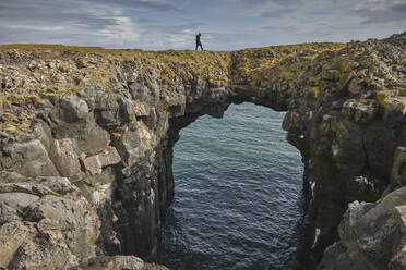 A basalt lava arch in the cliffs at the village of Arnastapi, Snaefellsjokull National Park, Snaefellsnes peninsula, west coast of Iceland, Polar Regions - RHPLF26699