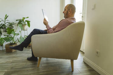 Senior man using tablet PC at home - OSF01953