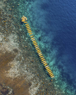 Aerial view of yellow canoes along the coastline at El Nido Bay, Palawan, Philippines. - AAEF21018