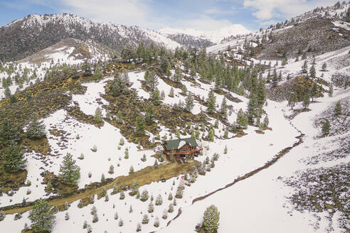Aerial view of a snowy house along the Swauger Creek, California, United States. - AAEF21325