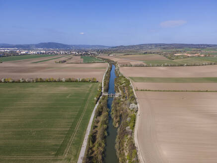 Aerial drone view of an irrigation canal, fields, paths, and a dam, Gerasdorf, Lower Austria, Austria. - AAEF21400