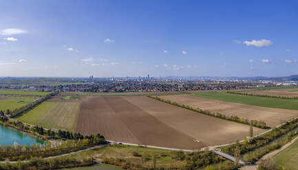 Aerial drone panoramic view of farmland and district 22, Donaustadt, Vienna in the distance, Gerasdorf, Lower Austria, Austria. - AAEF21402