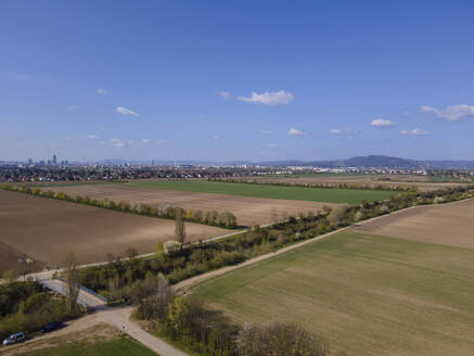 Aerial drone view of an irrigation canal with fields and district 22, Donaustadt, Vienna in the distance, Gerasdorf, Lower Austria, Austria. - AAEF21403