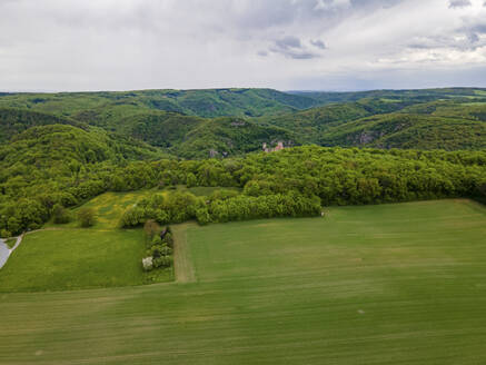 Aerial drone view in summer of Thayatal National Park with fields and parts of Hardegg Castle in the foreground and Czech Republic in the distance under storm clouds, Hardegg, Lower Austria, Austria. - AAEF21405