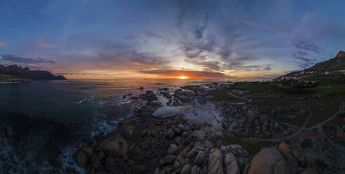 Panoramic aerial view of Maiden’s Cove Tidal Pool at dramatic sunset with Camps Bay in background, Cape Town, South Africa. - AAEF21418