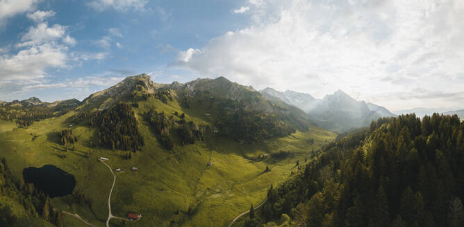 Drohnenaufnahme eines Sees, umgeben von üppigem grünen Gras, Grappelensee, Wildhaus, Laui, St. Gallen, Schweiz. - AAEF21554