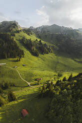 Aerial drone view a valley surrounded by alpine mountains at Laui, Wildhaus, St. Gallen, Switzerland. - AAEF21556