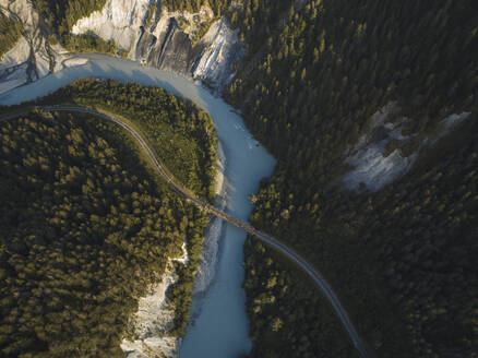 Aerial drone view of a canyon filled by a glacier river crossed by a railroad, Rheinschlucht, Flims, Graubunden, Switzerland. - AAEF21560