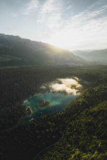 Aerial drone view a clear water lake covered in fog, Eibsee, Flims, Graubunden, Switzerland. - AAEF21570