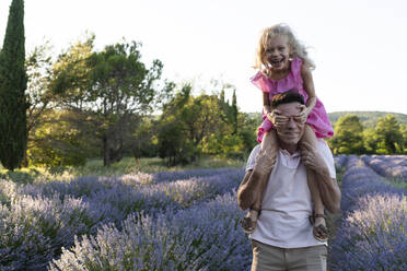 Happy girl covering eyes and having fun with father in lavender field - SVKF01592