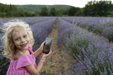 Happy girl with smart phone in lavender field - SVKF01599