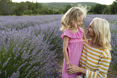 Lächelnde Frau mit Tochter im Lavendelfeld - SVKF01600