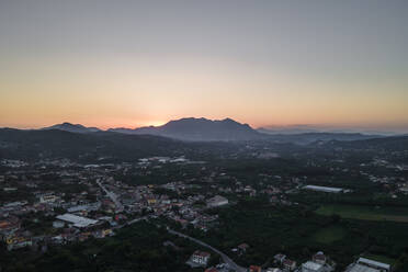 Aerial view of a valley with residential houses in Irpinia at sunset with Mount Vergine in background, Avellino, Italy. - AAEF21632