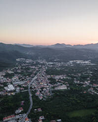 Aerial view of a valley with residential houses in Irpinia at sunset with Mount Vergine in background, Avellino, Italy. - AAEF21634