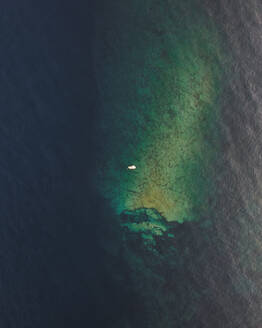 Aerial view of a sailing boat along the coast at sunset in Maratea beach, Potenza, Basilicata, Italy. - AAEF21679