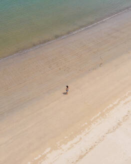 Aerial view of a person along the shoreline with a book at Baia de Sao Martinho do Porto, Leiria, Portugal. - AAEF21683