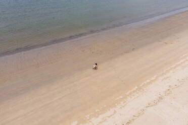 Aerial view of a person along the shoreline with a book at Baia de Sao Martinho do Porto, Leiria, Portugal. - AAEF21684