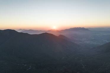 Aerial view of the sun setting down across the valley in Serino along the Mount Terminio with National park, Campania, Avellino, Italy. - AAEF21694