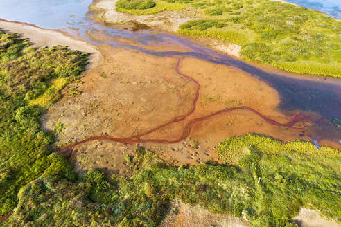 Aerial view of red streams flowing into a small river in Hraundalur, Westfjords, Iceland. - AAEF21781