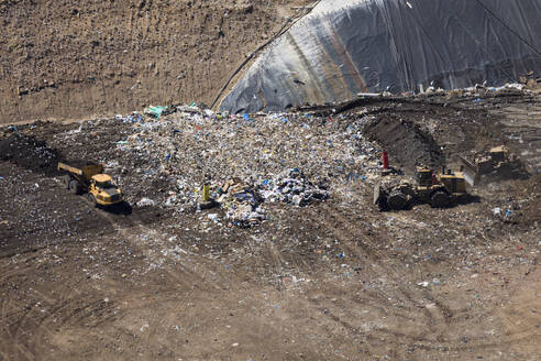 Aerial view of landfill with landfill machinery working on the ground in Melbourne, Victoria, Australia. - AAEF21868