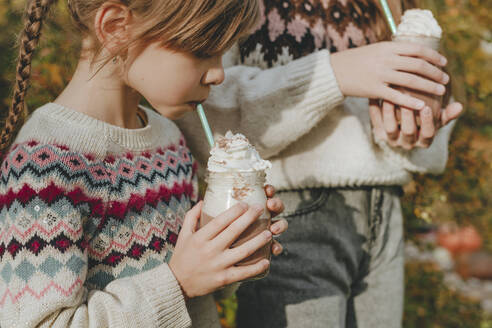 Mädchen trinken Milchshake im Garten - YTF01051