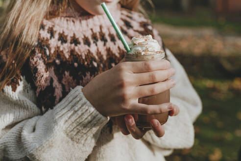 Mädchen im Pullover hält ein Glas Milchshake - YTF01052