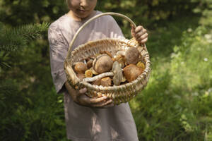 Mädchen hält Korb mit Pilzen im Wald - LESF00418