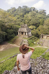 Man wearing hat looking at Mayan old ruins - MMPF00807