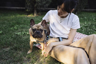 Frau streichelt Hund im Park - YBF00093