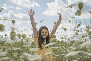 Glückliches Mädchen mit erhobenen Händen in einem Blumenfeld - OSF01964