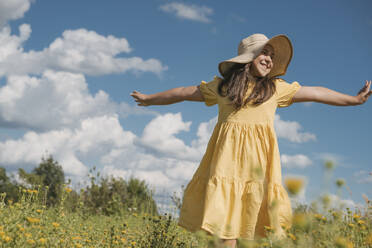 Happy girl with arms outstretched in field on sunny day - OSF01973