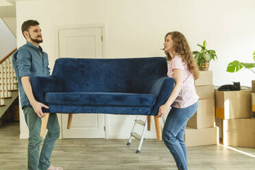 Junges Paar mit blauem Sofa im neuen Haus - OSF01981