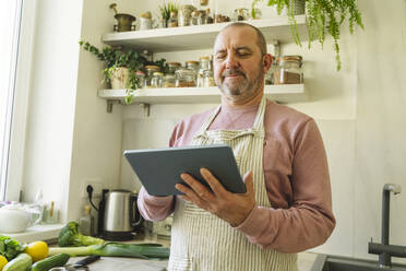 Senior man using tablet PC at home - OSF01986