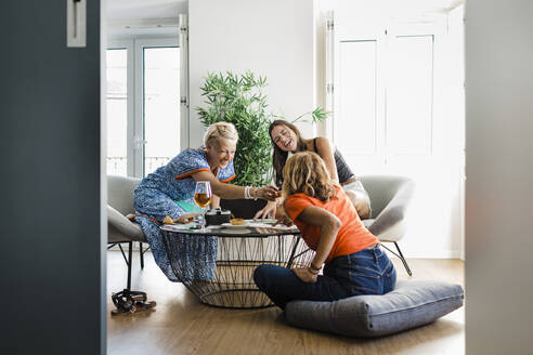 Fröhliche Freunde, die zusammen in einer Wohnung Snacks zu sich nehmen - DCRF01689