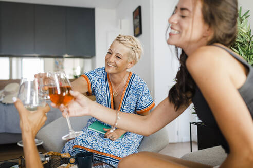 Happy friends enjoying and toasting wineglasses in apartment - DCRF01691