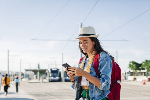 Happy woman wearing hat using mobile phone - DCRF01733