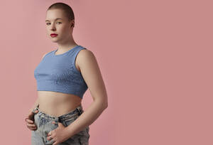 Junge Frau posiert vor rosa Hintergrund - KPEF00163