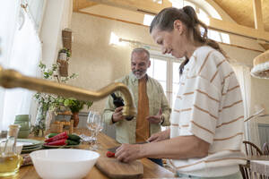 Paar, das sich gegenseitig bei der Zubereitung von Speisen in der Küche hilft - VPIF08361