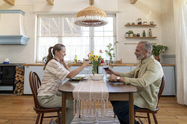 Ehepaar genießt Wein am Esstisch in der Küche - VPIF08370