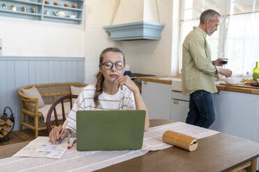 Woman preparing bills with man in kitchen at home - VPIF08379