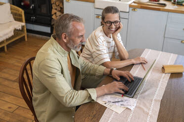 Ehepaar erstellt Finanzrechnungen mit Laptop zu Hause - VPIF08389