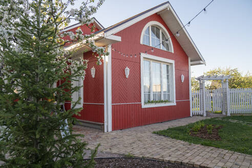 Rotes Haus mit Lichterketten an Bäumen im Hinterhof - VPIF08434