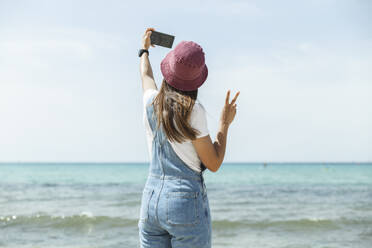 Woman taking selfie near sea under sky - PCLF00667