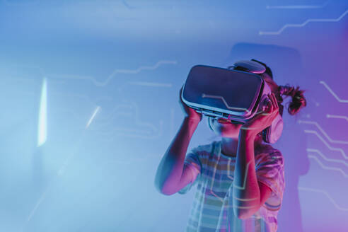 Mädchen trägt Virtual-Reality-Simulatoren in Neonlicht - YTF01081